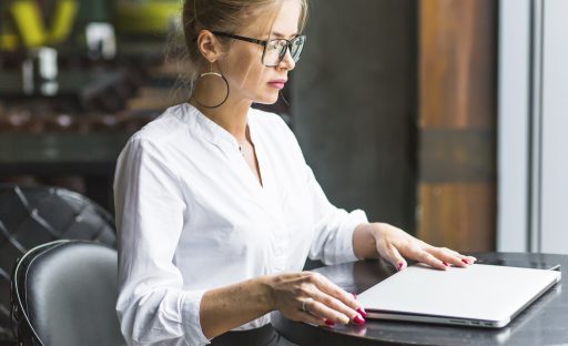 side-view-woman-sitting-restaurant-with-laptop